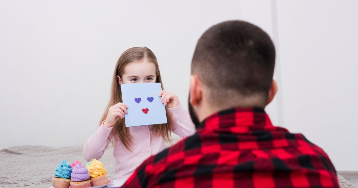 Parent helping preschool child identify emotions using feelings chart, teaching emotional intelligence and self-awareness