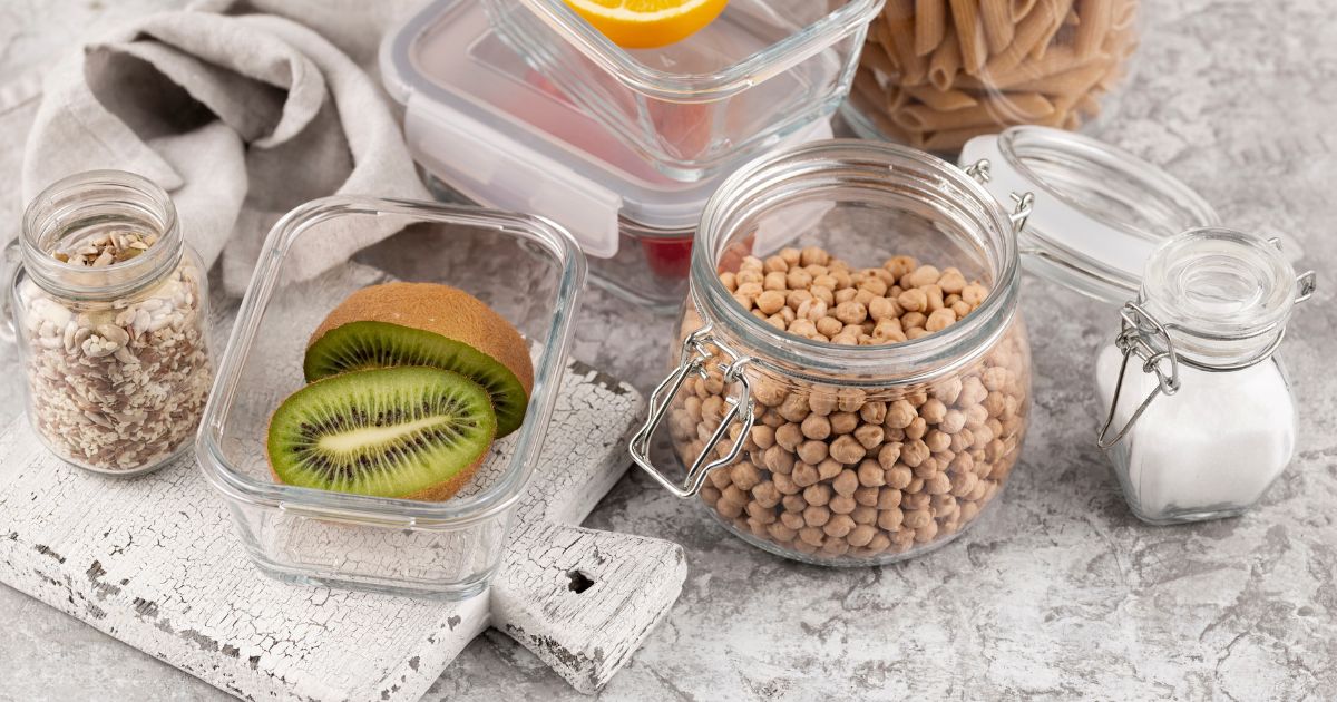 Circular kitchen with glass jars, beeswax wraps, stainless steel containers, and compost bin, zero waste sustainable home"