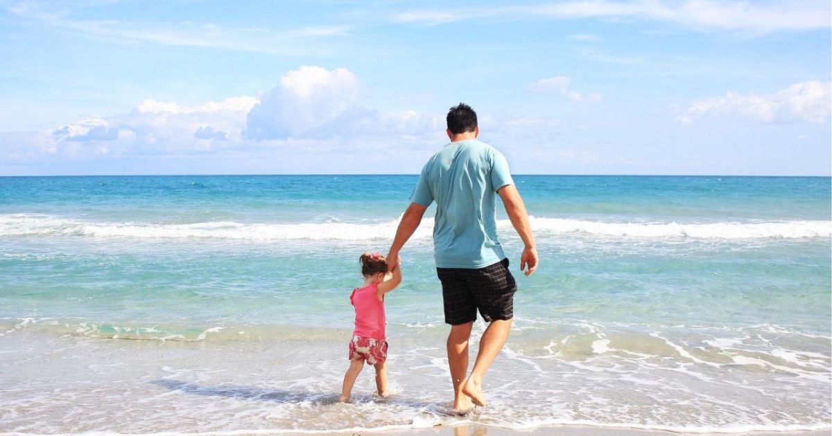 Family walking together on nature trail at sunset, holding hands, building lifelong connections through shared experiences"