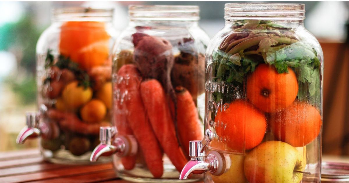 Homemade bioenzymes fermenting in glass jars with citrus peels, natural cleaning solution made from kitchen scraps