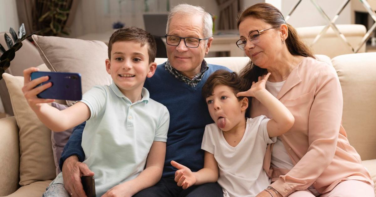 Grandmother reading to grandchildren on couch, multi-generational family connection and bonding