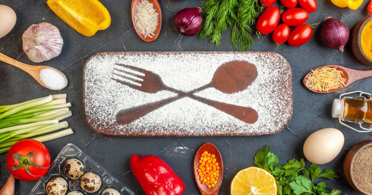 Cast iron skillet, silicone food covers, stainless steel compost bin, and bread tools arranged on kitchen counter, best zero waste kitchen gifts