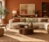 Current editorial living room with warm terracotta wall, walnut table, soft cream sofa and layered woven textures