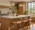 Inviting kitchen with natural warm oak cabinetry, simple off-white stone-look counter, practical handles and soft daylight